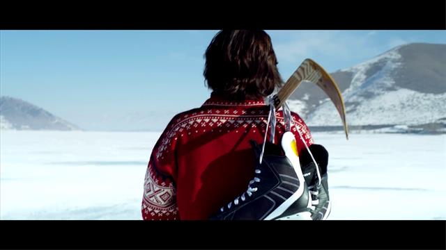 Back Of Man Walking On Iced Ground Holding Ice Hockey Stick